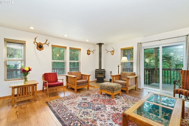 sitting room featuring hardwood / wood-style flooring and a wood stove