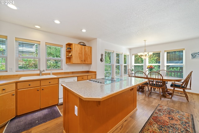 kitchen with black electric stovetop, white dishwasher, sink, light hardwood / wood-style flooring, and a kitchen island