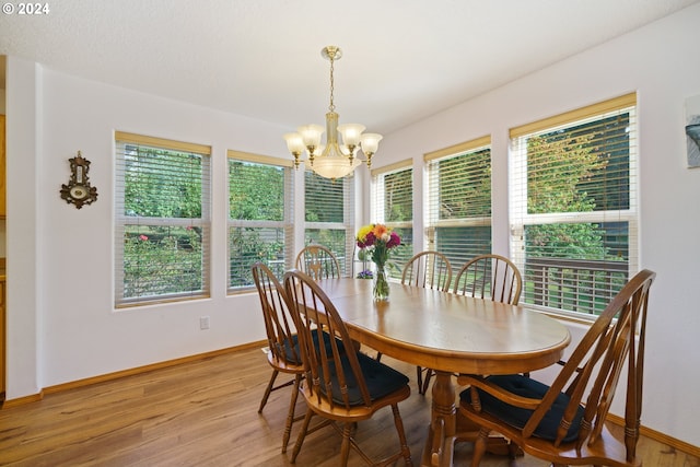 dining room with light hardwood / wood-style flooring, an inviting chandelier, and a wealth of natural light