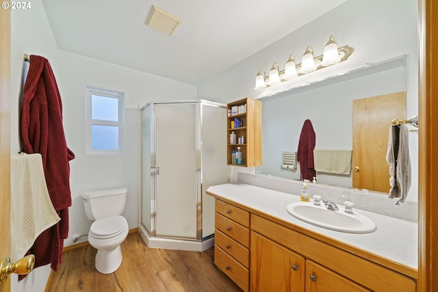 bathroom featuring vanity, toilet, wood-type flooring, and walk in shower