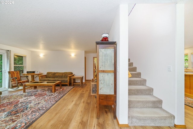 staircase featuring hardwood / wood-style floors and a textured ceiling