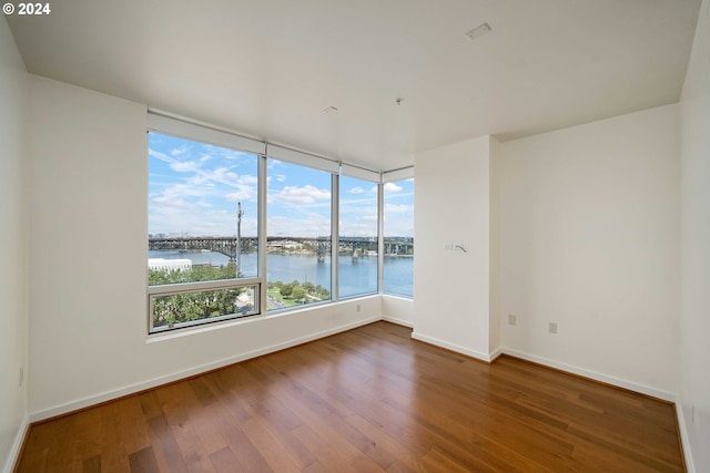 spare room featuring a water view and hardwood / wood-style floors