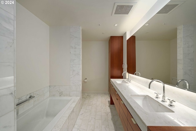 bathroom featuring dual bowl vanity, a relaxing tiled tub, and tile patterned flooring