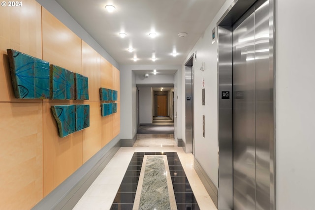 hallway with elevator and light tile patterned floors