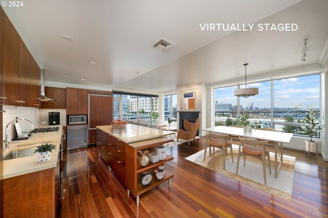 kitchen featuring tasteful backsplash, pendant lighting, appliances with stainless steel finishes, and dark hardwood / wood-style floors