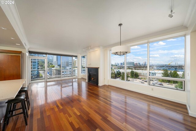 living room featuring ornamental molding, dark hardwood / wood-style flooring, and a healthy amount of sunlight