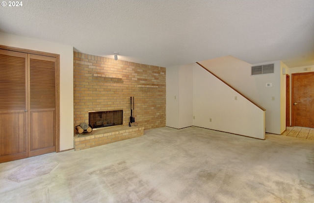 unfurnished living room featuring a fireplace, light colored carpet, and a textured ceiling