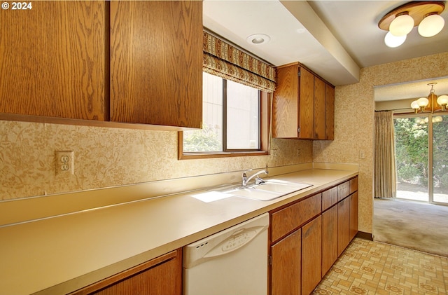 kitchen featuring dishwasher, sink, light carpet, and an inviting chandelier