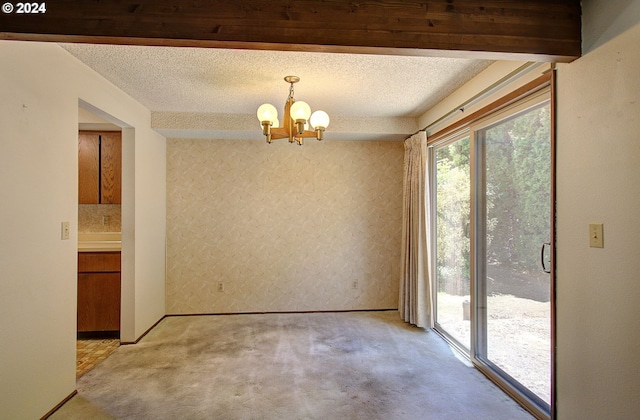 unfurnished dining area with a chandelier, light carpet, and a textured ceiling