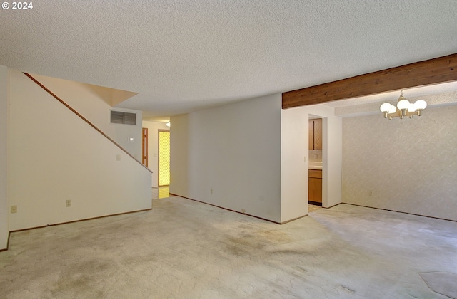 unfurnished room featuring beamed ceiling, light colored carpet, a textured ceiling, and a chandelier