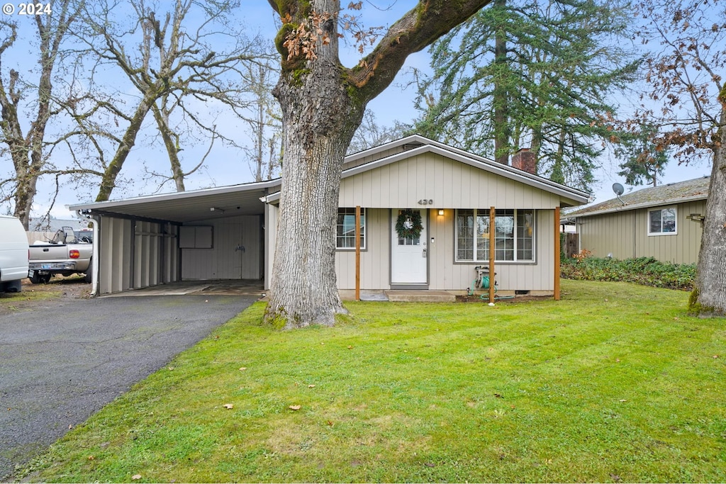 view of front of house with a front yard, a porch, and a carport