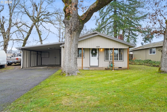 view of front of house with a front yard, a porch, and a carport