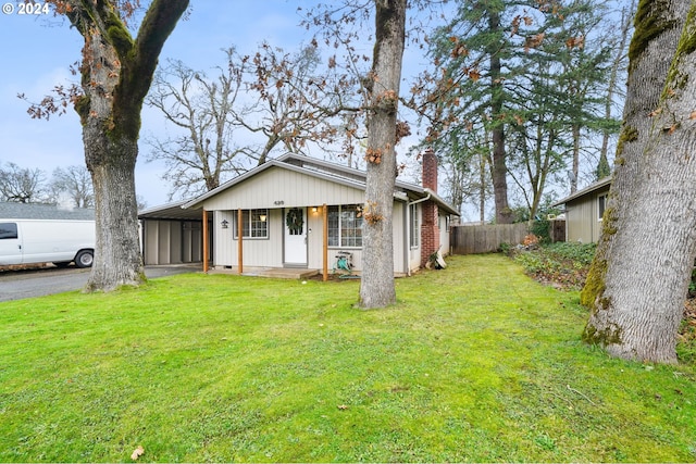 single story home featuring a front lawn and a carport