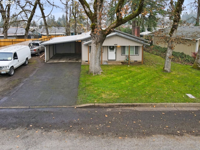 ranch-style house featuring a front yard and a carport