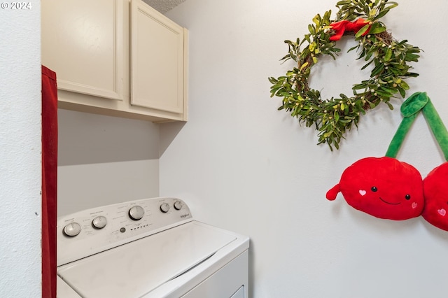 laundry room featuring washer / clothes dryer and cabinets