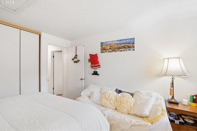 bedroom featuring a closet, hardwood / wood-style flooring, and a textured ceiling