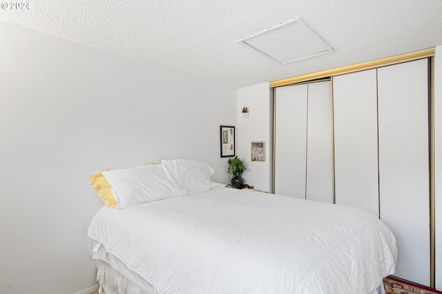 bedroom with a textured ceiling and a closet