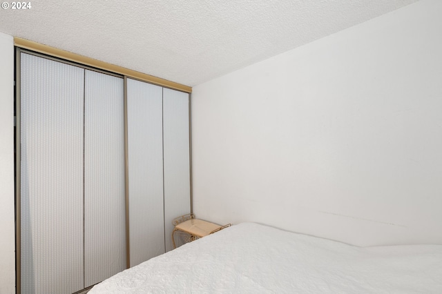 bedroom with a textured ceiling and a closet