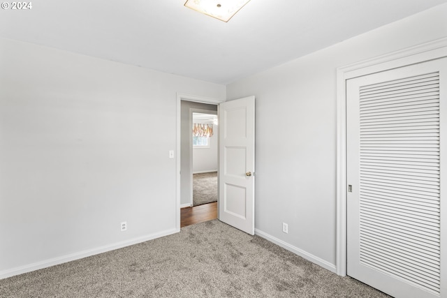 unfurnished bedroom with light carpet and a closet