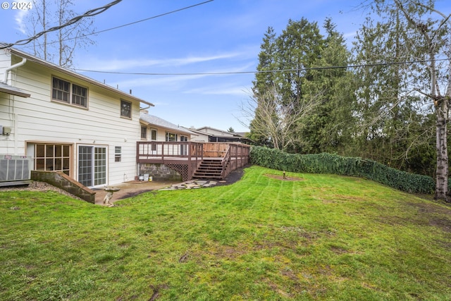 view of yard with a deck and central AC unit