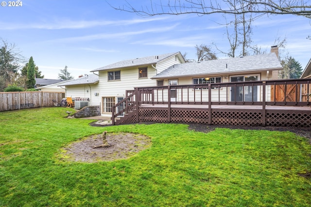 rear view of house with a yard and a deck