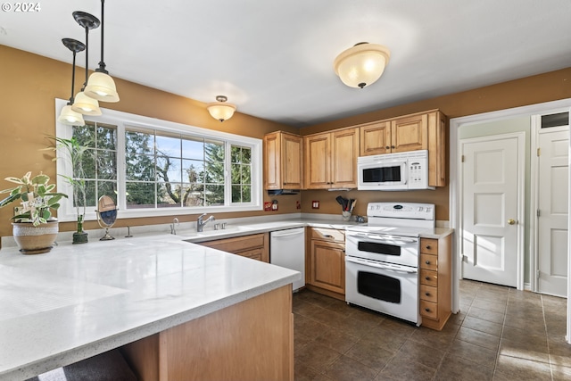 kitchen with white appliances, pendant lighting, sink, and dark tile floors