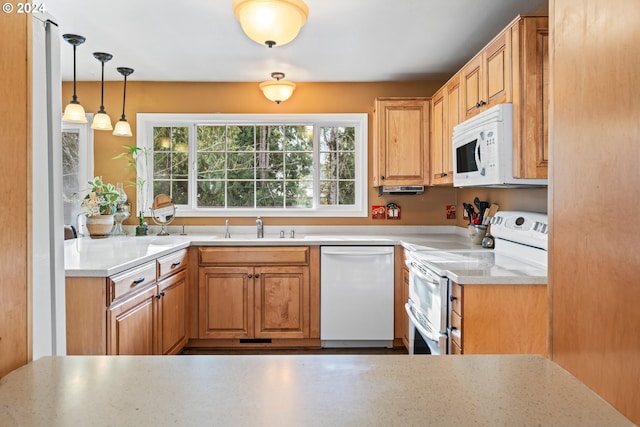 kitchen with sink, white appliances, and pendant lighting