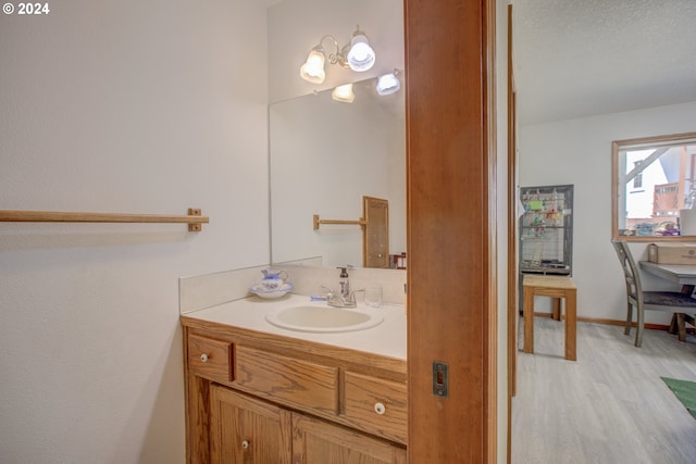 bathroom featuring vanity, hardwood / wood-style flooring, and an inviting chandelier