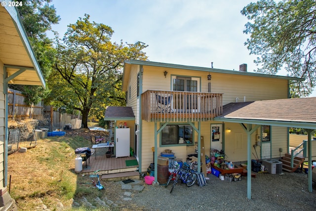 rear view of house with a balcony, cooling unit, and a deck