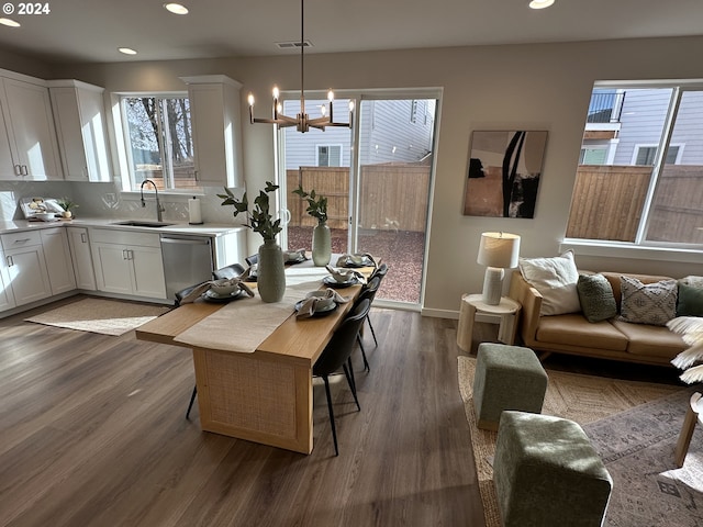 dining space featuring dark hardwood / wood-style floors, sink, and a chandelier