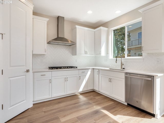 kitchen featuring white cabinets, sink, wall chimney exhaust hood, and stainless steel appliances