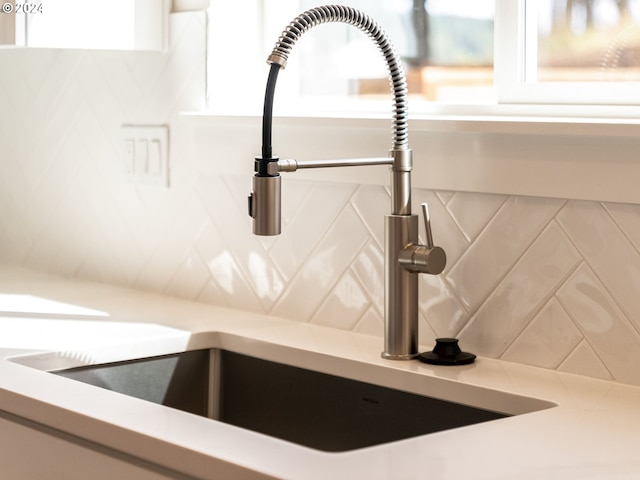 interior details featuring tasteful backsplash and sink