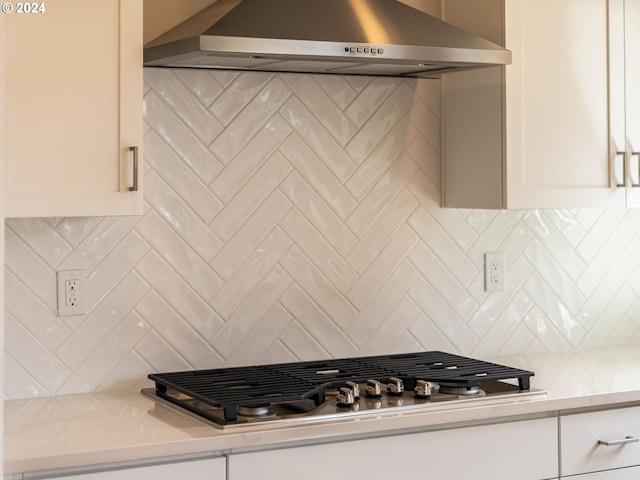 kitchen featuring decorative backsplash, stainless steel gas stovetop, and wall chimney range hood