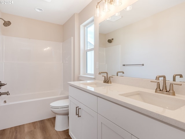 full bathroom with bathing tub / shower combination, toilet, vanity, and hardwood / wood-style flooring