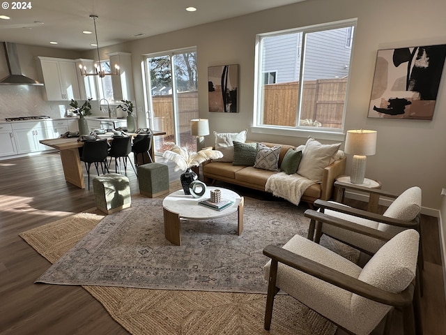 living room featuring sink, dark wood-type flooring, and a chandelier