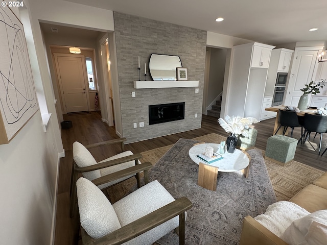 living room featuring a fireplace and dark wood-type flooring