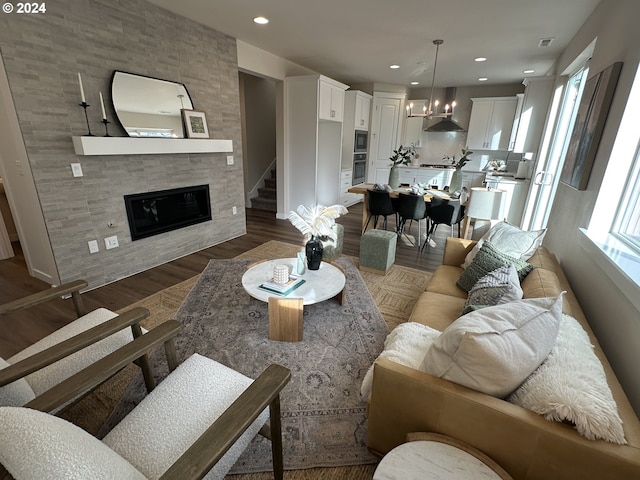 living room featuring a large fireplace and wood-type flooring