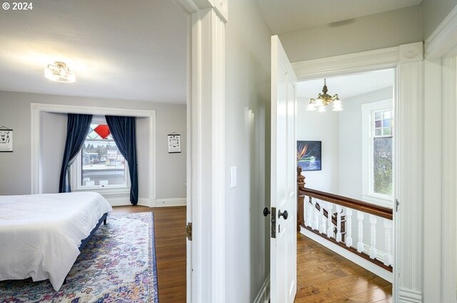 bedroom with hardwood / wood-style flooring and a chandelier