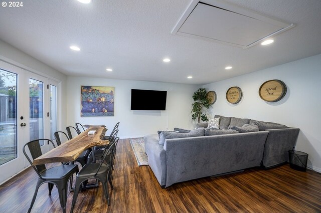 living room with a textured ceiling, french doors, and dark hardwood / wood-style floors
