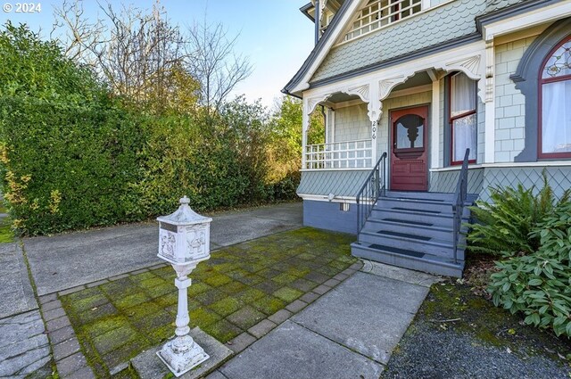 doorway to property with covered porch and a balcony