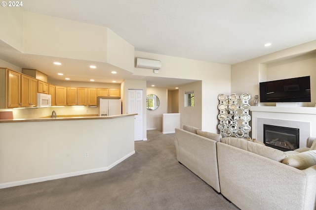 living room featuring a fireplace, a wall unit AC, sink, and light carpet