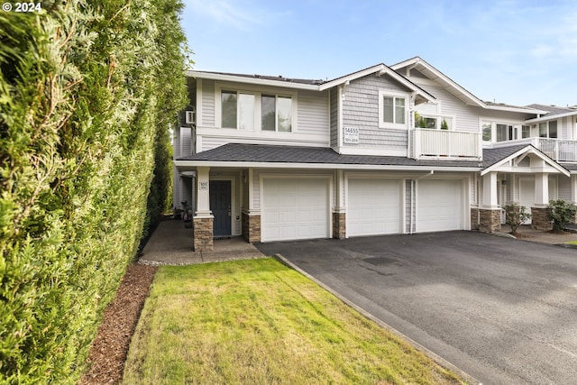 view of front facade with a garage, a balcony, and a front lawn