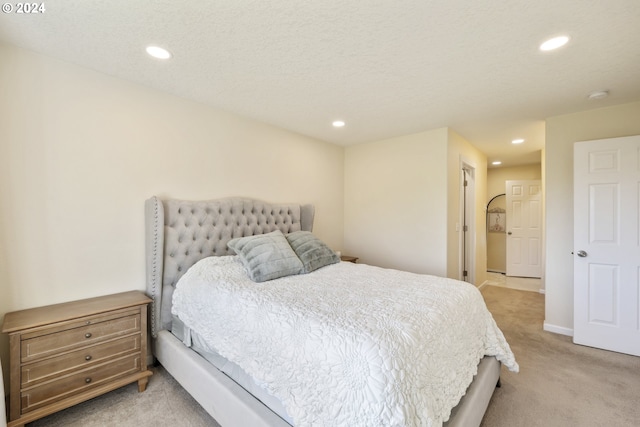 bedroom featuring light carpet and a textured ceiling