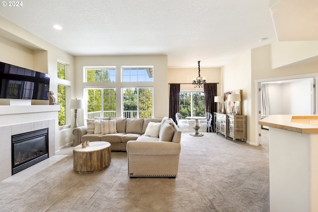 living room with light carpet, a textured ceiling, plenty of natural light, and a tile fireplace