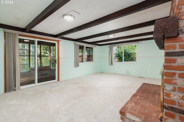 interior space with beamed ceiling, a textured ceiling, and carpet