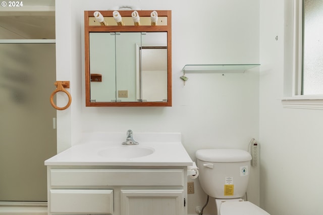 bathroom with vanity, toilet, and a shower with shower door