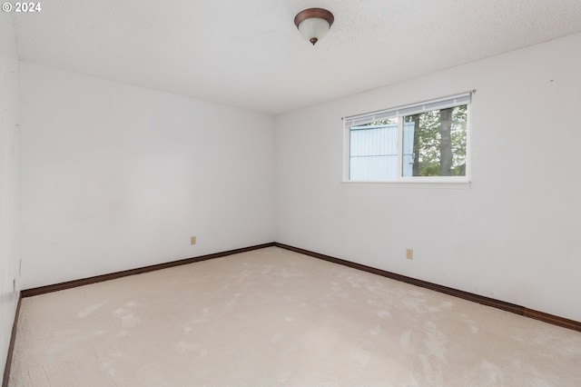 carpeted spare room featuring a textured ceiling