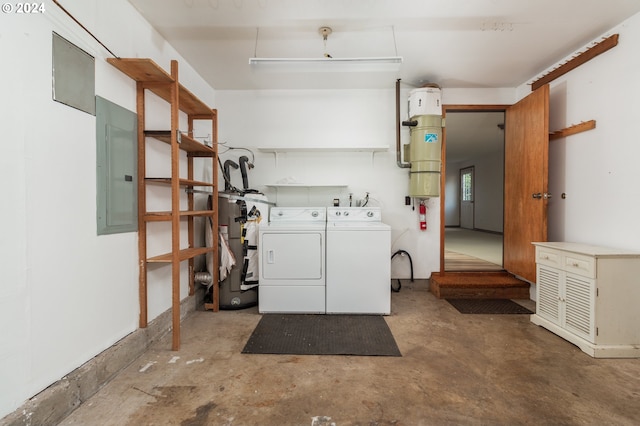 clothes washing area with electric water heater, separate washer and dryer, and electric panel