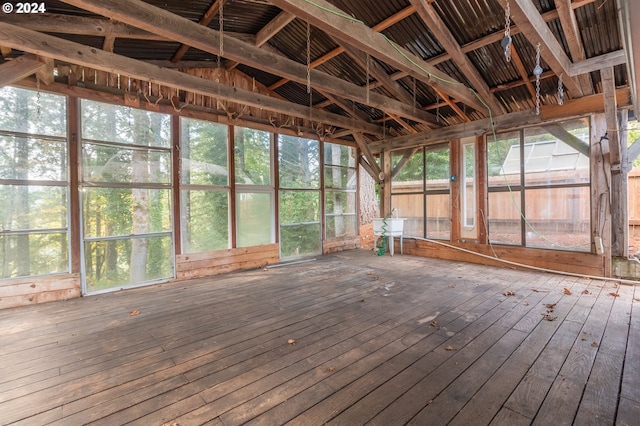 unfurnished sunroom featuring lofted ceiling and plenty of natural light