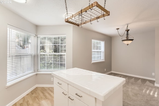 8550 SW Curry Dr Unit A, Wilsonville, OR 97070 - kitchen with tile countertops, plenty of natural light, baseboards, and hanging light fixtures